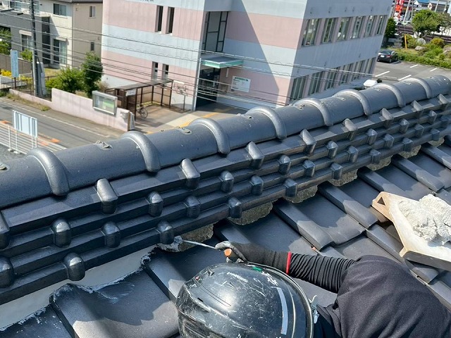 平瓦とのし瓦の間に新しい漆喰を専用のコテで詰め込んでいる様子