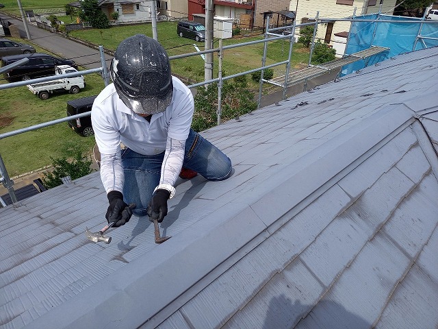 屋根カバー工法メンテナンスで棟板金の釘をバールで抜いている様子