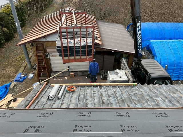 瓦屋根葺き替え工事で使用する屋根材をユニック車で搬入している状況