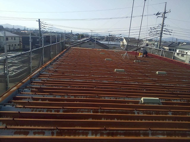 石岡市のアパートでサビ止め塗料「マイルドボーセイ」を用いた折板屋根塗装の下塗り