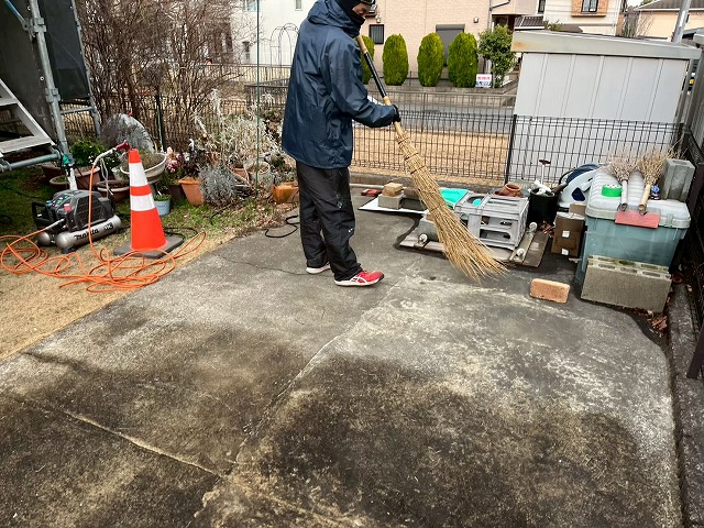 外壁まわりに飛散した塗料やゴミを丁寧に清掃している作業の様子