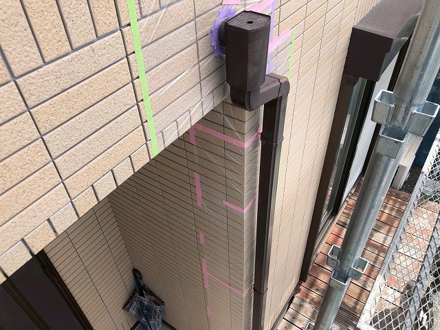 雨樋の縦樋にマスカーを使って養生を施している様子