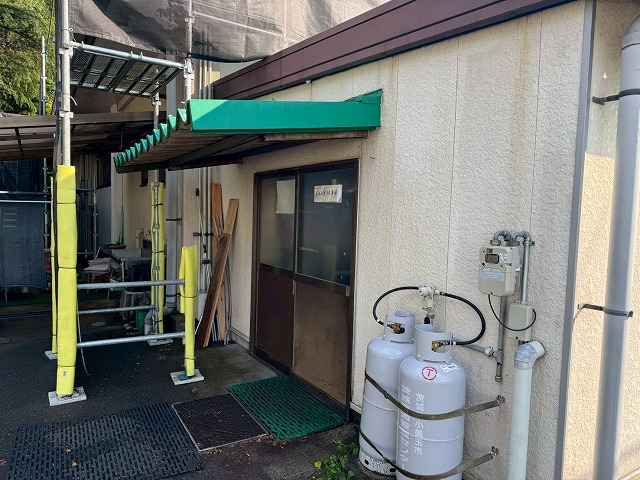足場が組まれたキャディー棟入口付近のサイディング外壁