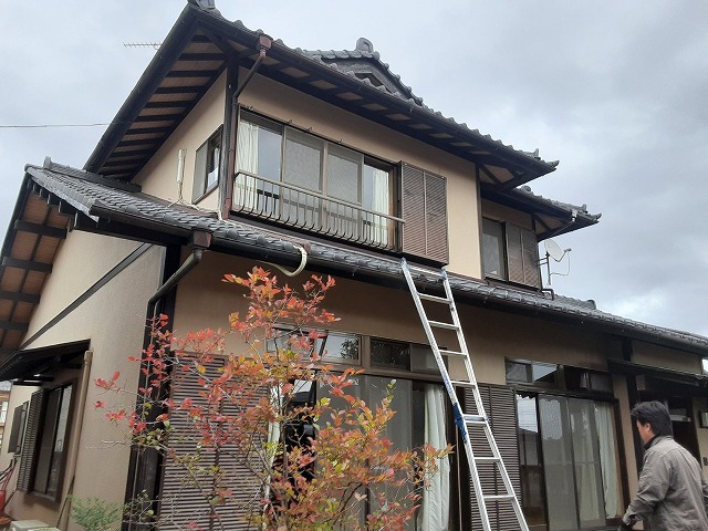 入母屋屋根の住宅で雨漏り調査を行っている様子
