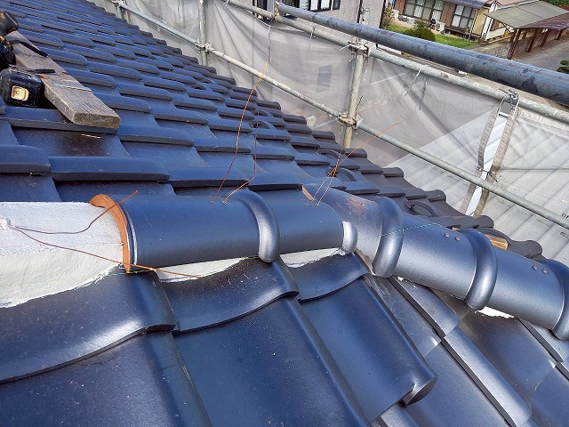 屋根葺き替え工事風切丸仕上げ工程の丸瓦へ銅線を通した状況