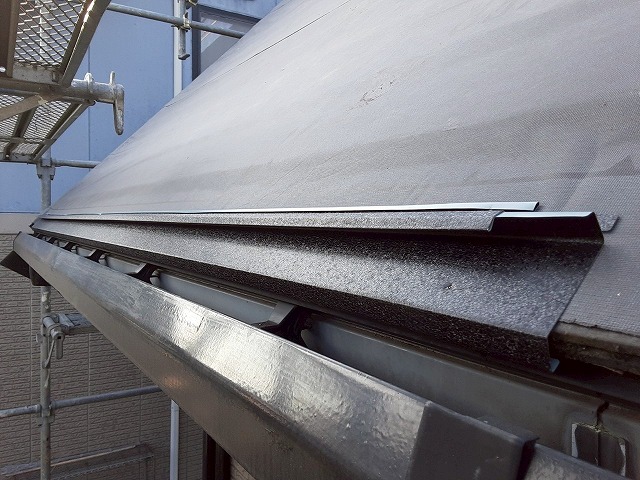 屋根カバー工事で軒先部分へスーパーガルテクトの水切り役物を取り付けている状況