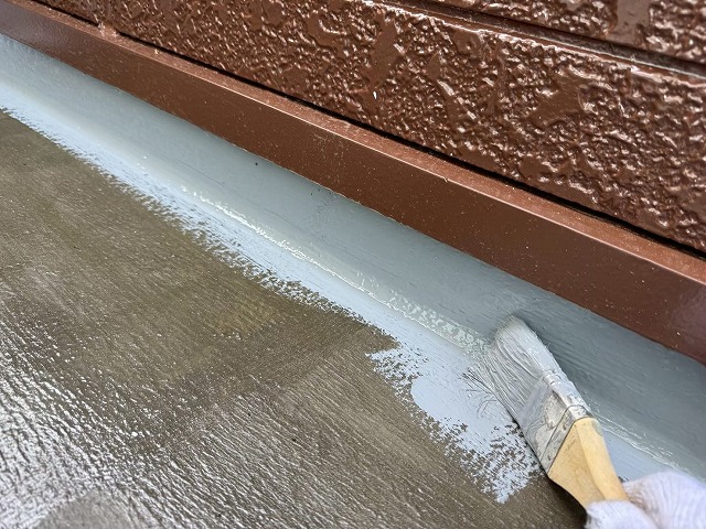 ベランダ防水修繕工事の立ち上がりへのウレタン塗膜防水材1層目施工