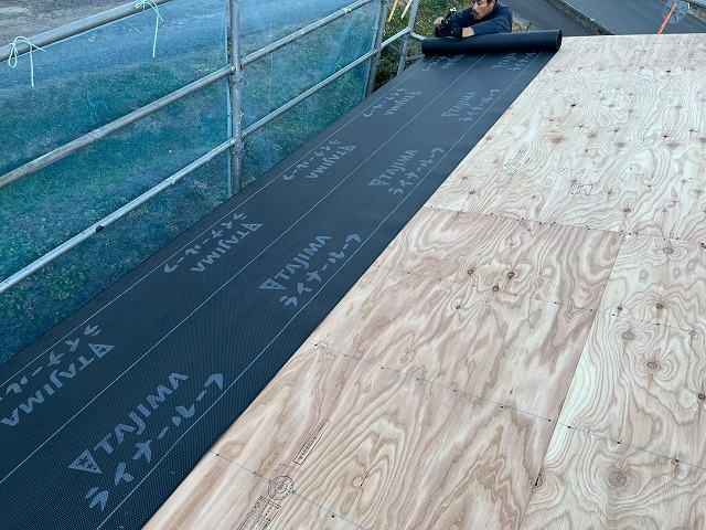 新築住宅屋根仕上げ工事で軒先部分へ防水シートの施工を行う屋根職人