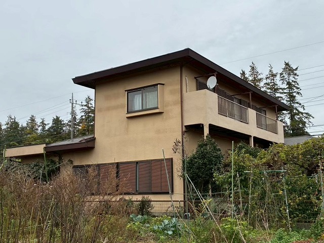 モルタル塗り外壁に多くの経年劣化が生じていた住宅の外観