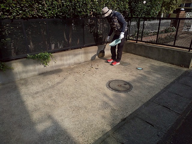 屋根カバー工事完了後に駐車スペースを清掃する屋根職人