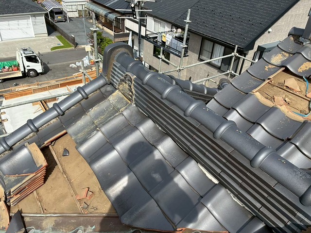 住宅屋根葺き替え工事で瓦屋根の一部を解体している様子