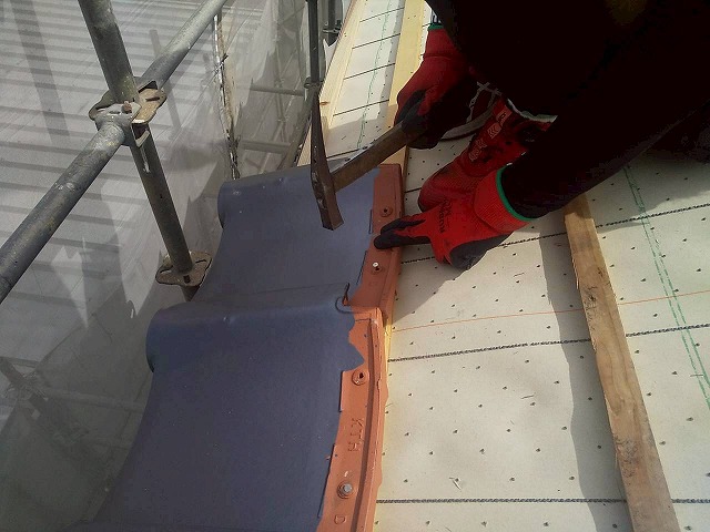 屋根葺き替え工事で軒瓦に釘を打ち付けている様子