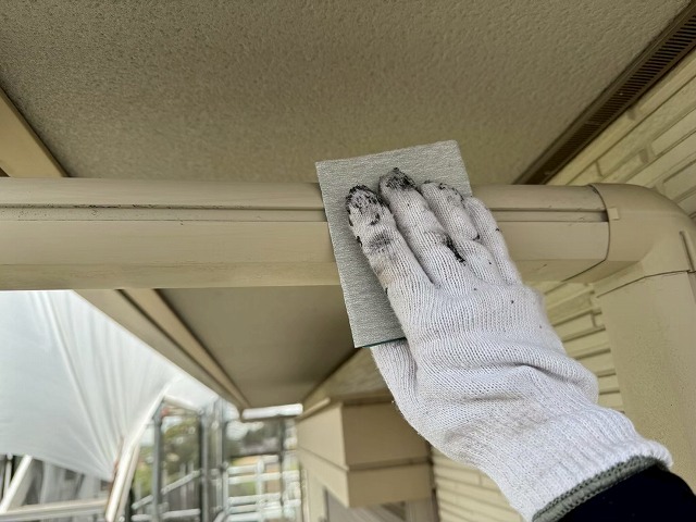 アパート建物塗装工事の雨樋へのケレン処理の様子