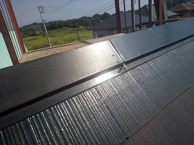 カラーベスト屋根カバー工事で棟板金を撤去するためにビスを抜いている状況