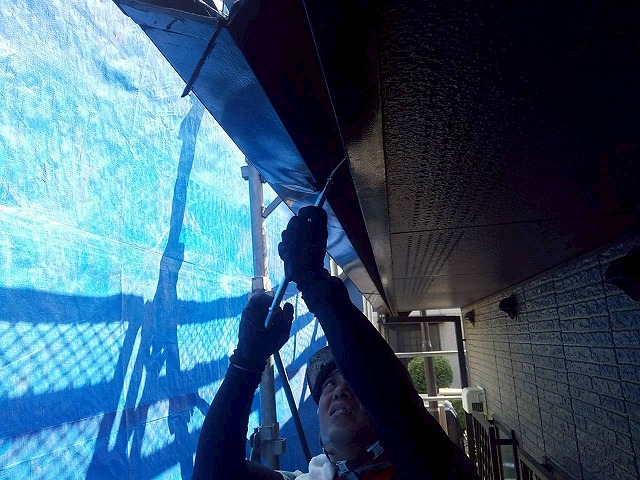 雨樋交換工事でバールを使って既存軒樋を取り外している状況