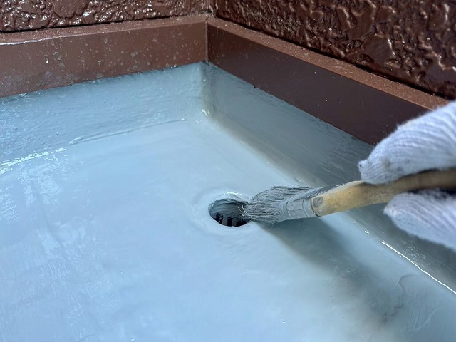 ベランダ防水修繕工事のドレンまわりへのトップコート塗布