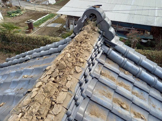 屋根葺き替え工事の既存の冠瓦を取り外している様子