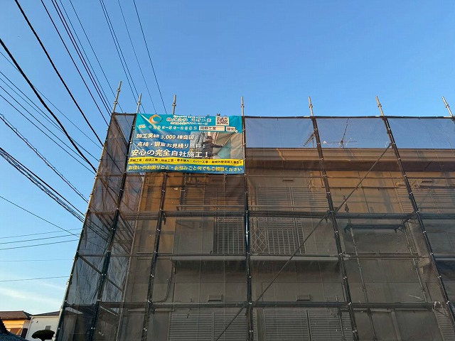 アパート折板屋根塗装工事の足場へイメージシートを設置している状況
