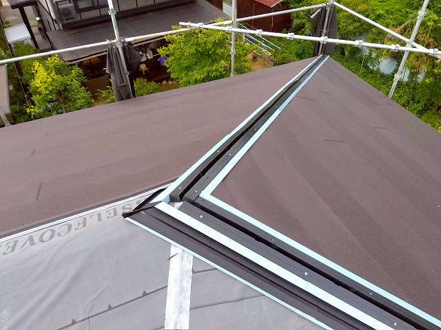 隅棟部のC型捨板にスーパーガルテクトを差し込んで雨仕舞と美観を確保している様子