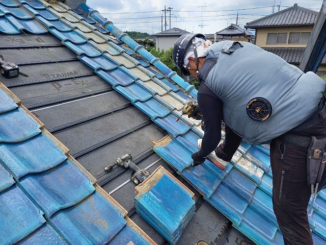 屋根葺き直し工事で瓦をステンレスビスで固定する屋根職人