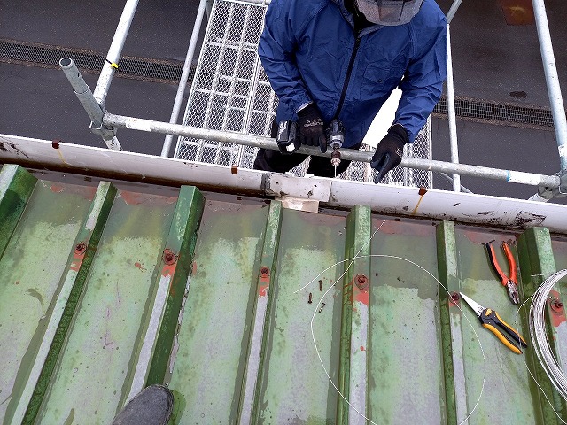 工場建物のローリングタワーによる雨樋の補修工程