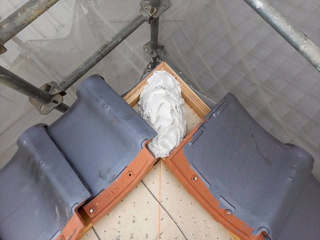 屋根葺き替え工事の隅棟の先端に漆喰材を盛り付け