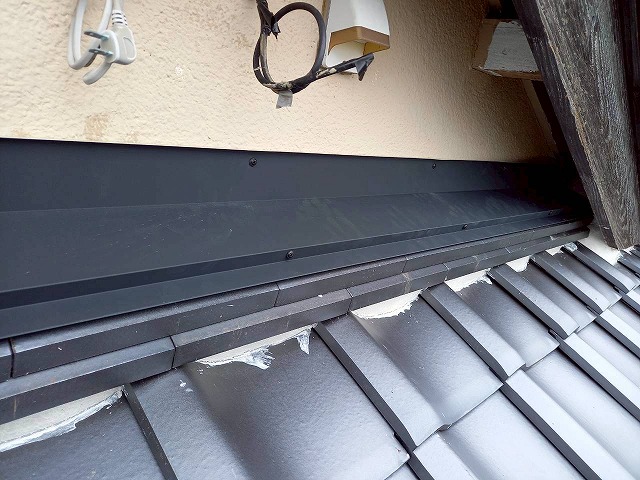 屋根葺き替え工事で下屋根と外壁との取り合い部への雨押え板金の取り付けが完了