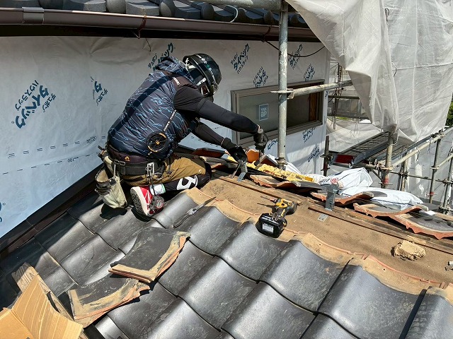 下屋根の棟取り直し工事で補強金具を取り付ける屋根職人
