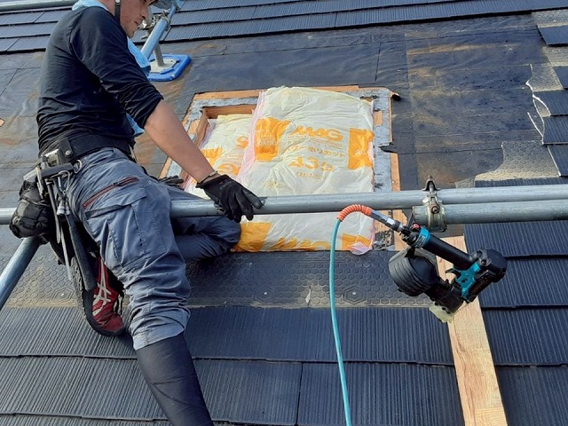 屋根トップライト撤去工事で生じた開口部へ断熱材を充填している状況