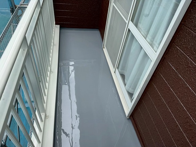 ベランダ防水工事のカラーウレタン塗膜防水材を用いた1回目塗布の様子