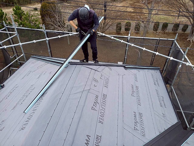 住宅屋根カバー工事でC型捨板を加工している様子