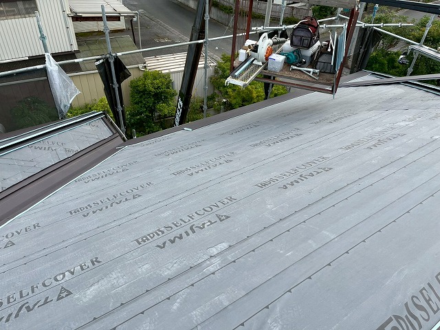 軒先の改修用唐草にスーパーガルテクトを引っ掛けて本体施工を開始している様子
