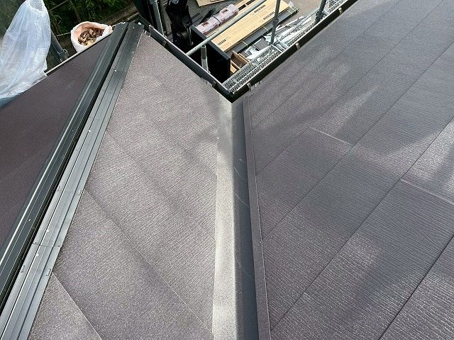 谷部の金属屋根本体端部に谷止縁を差し込んで端部を美しく納めている施工の様子