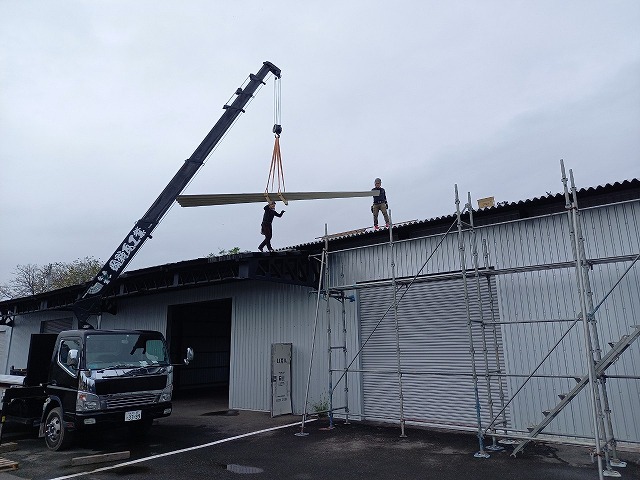 貸倉庫の屋根カバー工事で使用する折板屋根をユニック車で搬入している様子