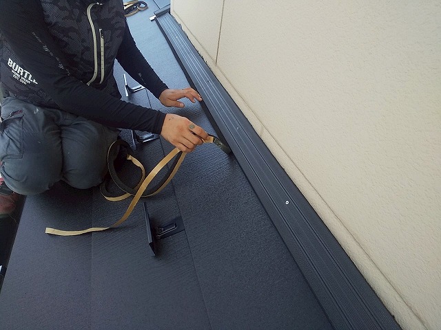 下屋根カバー工事の貫板の横に防水シーラーを貼り付ける屋根職人