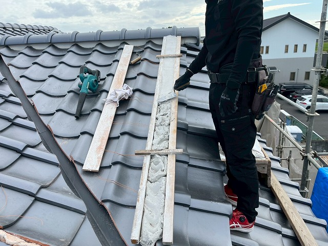 風切丸の土台となる漆喰材を型枠に詰め込んで均している様子