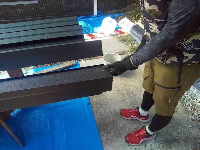 屋根カバー工事の改修用ケラバ水切りに折り曲げ加工を施している様子