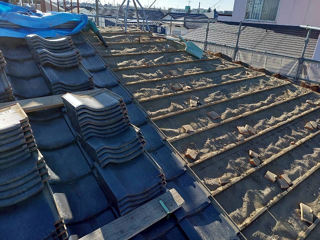 屋根葺き直し工事で再利用する瓦材を簡易的に設けた足場スペースに仮置き