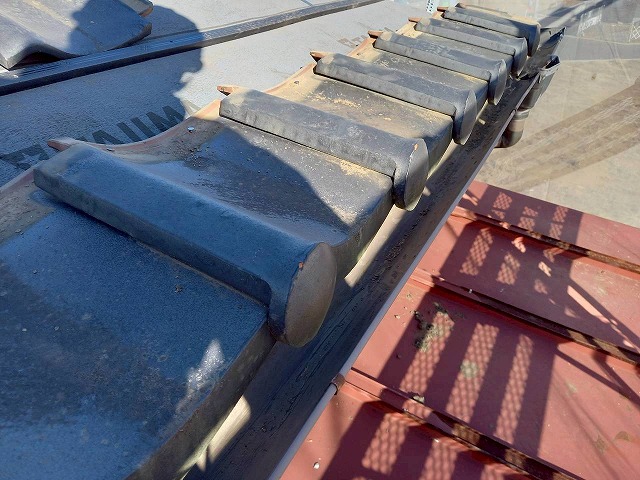 屋根葺き直し工事で取り外していた軒瓦を再設置している状況