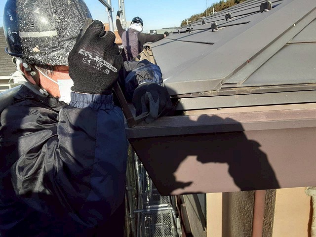 雨樋交換工事で樋隠しを固定する釘を抜いている様子