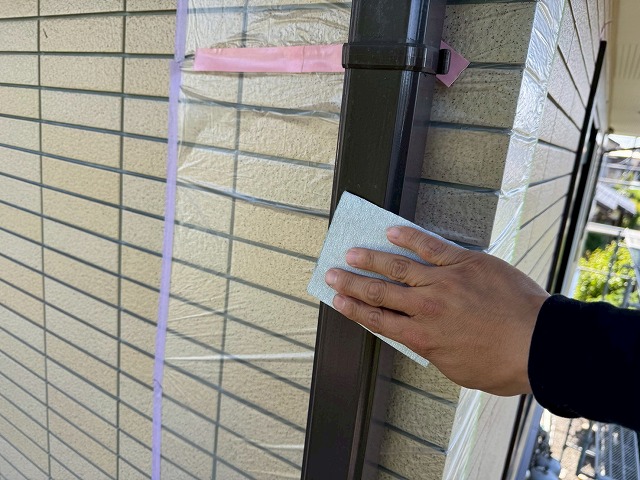 雨樋表面をサンドペーパーでケレン処理している様子