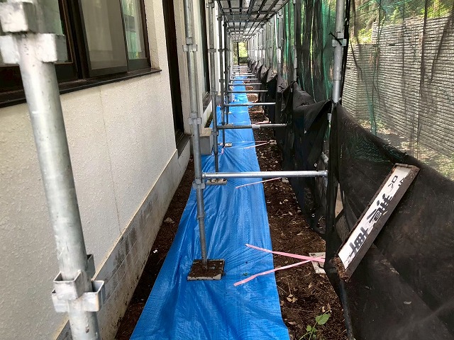 建物まわりの足元に敷いたブルーシートで地面を保護している養生の様子