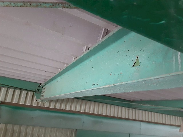 工場建物の鉄骨梁に色あせや塗膜ががれが生じている様子