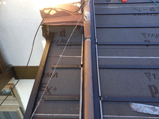 屋根葺き替え工事で下屋根壁際へ取り付けた捨て水切りを軒先まで延長