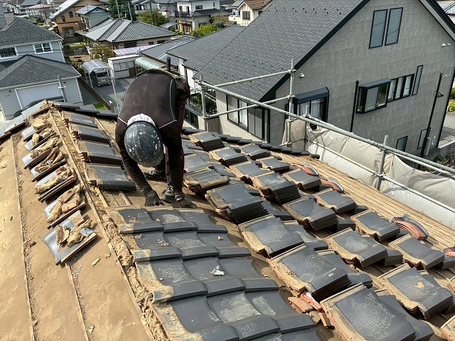 住宅屋根葺き替え工事で瓦の解体を行う屋根職人