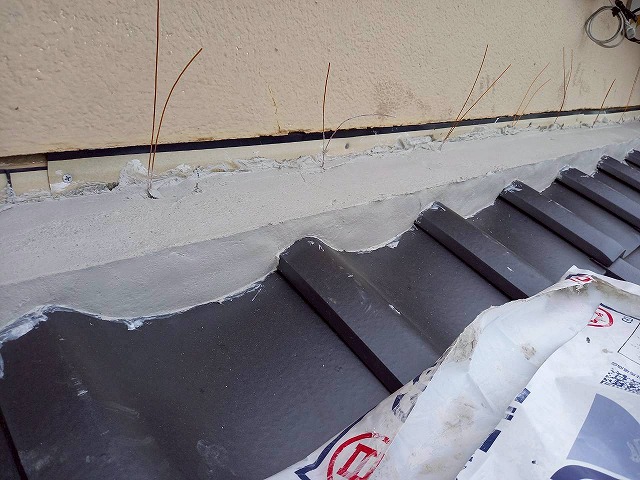 屋根葺き替え工事で下屋根と外壁との取り合い部につくった土台の成形