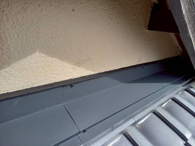 屋根葺き替え工事の外壁と雨押え板金との取り合い部へのコーキング処理