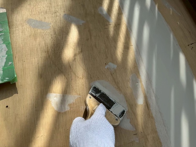 ウレタン塗膜防水工事の合板下地ビス頭へのパテ塗り付け状況