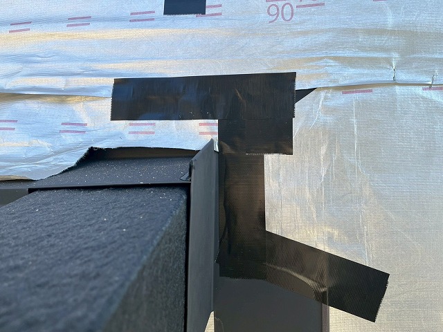 下屋根壁取り合い部へ設置した雨押え役物端部への防水テープ処理