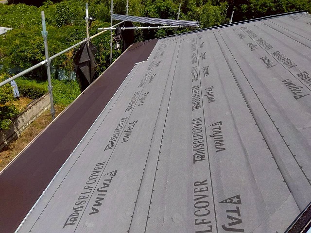 スーパーガルテクトの本体施工が軒先側から棟方向へ進んでいる途中の屋根の状況